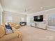 Spacious living room includes large sectional sofa, TV, and lots of natural light at 8912 Heydon Hall Cir, Charlotte, NC 28210