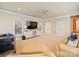 Spacious living room featuring a large sectional sofa, TV, and lots of natural light at 8912 Heydon Hall Cir, Charlotte, NC 28210