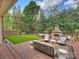 An outdoor space features a fireplace, artificial turf, brick patio, and lush landscaping at 8912 Heydon Hall Cir, Charlotte, NC 28210