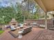 A large brick outdoor space with fireplace, grill, and seating at 8912 Heydon Hall Cir, Charlotte, NC 28210
