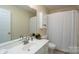 Bathroom featuring an elegant mirror, white sink, and shower with white tiles at 907 Bethpage Rd, Kannapolis, NC 28081