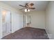 Bedroom with bathroom access, ceiling fan, carpet, closet, and access to a hallway featuring wood floors at 907 Bethpage Rd, Kannapolis, NC 28081