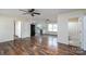 Open-concept living room boasts wood floors, ceiling fan, and access to the kitchen and bathroom at 907 Bethpage Rd, Kannapolis, NC 28081