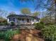 Charming ranch-style home with a welcoming front porch, lush landscaping, and a stone pathway at 925 Lanier Ln, Monroe, NC 28110