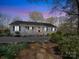 Charming ranch-style home with a welcoming front porch, lush landscaping, and a stone pathway at 925 Lanier Ln, Monroe, NC 28110