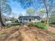 Charming ranch-style home with a welcoming front porch, lush landscaping, and a stone pathway at 925 Lanier Ln, Monroe, NC 28110