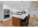 Stunning kitchen with white cabinets, stainless steel appliances, a large island with seating, and hardwood floors at 925 Lanier Ln, Monroe, NC 28110