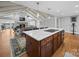 Open kitchen with white cabinets, stainless appliances, island cooktop, and open to the living room with a fireplace at 925 Lanier Ln, Monroe, NC 28110