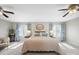 Sun-filled main bedroom featuring carpet, ceiling fans, blue patterned curtains, and a neutral color scheme at 925 Lanier Ln, Monroe, NC 28110