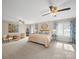 Bright main bedroom featuring carpet, ceiling fans, blue patterned curtains, and neutral color scheme at 925 Lanier Ln, Monroe, NC 28110