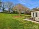 Expansive backyard with lush green grass and a patio seating area at 10107 Atkins Ridge Dr, Charlotte, NC 28213