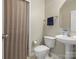 Cozy bathroom featuring a pedestal sink, toilet, and shower with neutral earth-toned walls at 10107 Atkins Ridge Dr, Charlotte, NC 28213