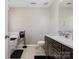 Modern bathroom with a soaking tub, dark cabinets, and wood-look tile floors at 10107 Atkins Ridge Dr, Charlotte, NC 28213