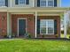 Cozy front porch with brick columns, lovely landscaping and a freshly-mowed lawn at 10107 Atkins Ridge Dr, Charlotte, NC 28213