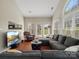 Bright living room with vaulted ceiling, large windows, and a comfortable sectional sofa at 10107 Atkins Ridge Dr, Charlotte, NC 28213
