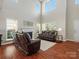 Cozy living room featuring high ceilings, a fireplace, and ample seating at 10107 Atkins Ridge Dr, Charlotte, NC 28213