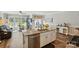 Bright kitchen island with stainless steel appliances connects to a cozy sunroom with natural light and serene backyard views at 1066 Chicory Trce, Lake Wylie, SC 29710