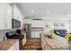 Open-concept kitchen with stainless steel appliances and granite countertops, seamlessly flowing into the living area at 1066 Chicory Trce, Lake Wylie, SC 29710