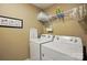 Functional laundry room features a washer, dryer, and storage shelf, maximizing space and efficiency at 1066 Chicory Trce, Lake Wylie, SC 29710