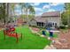 Landscaped backyard with outdoor seating, manicured lawn, and mature trees at 10823 Preservation Park Dr, Charlotte, NC 28214