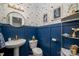 Unique powder room features geometric wallpaper, blue wainscoting, and gold accents at 10823 Preservation Park Dr, Charlotte, NC 28214