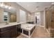 Spa-like bathroom with dual vanities, a soaking tub, a glass enclosed shower and access to the walk-in closet at 10823 Preservation Park Dr, Charlotte, NC 28214