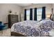 Comfortable bedroom with a queen bed, dresser, and natural light from two windows at 10823 Preservation Park Dr, Charlotte, NC 28214