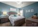Comfortable bedroom with blue walls, wood furniture, and decorative art at 10823 Preservation Park Dr, Charlotte, NC 28214