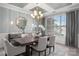 Elegant dining room with a decorative light fixture, mirror, and large window at 10823 Preservation Park Dr, Charlotte, NC 28214