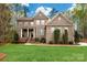 Charming brick two-story home with manicured lawn, stately columns, and mature trees at 10823 Preservation Park Dr, Charlotte, NC 28214