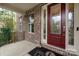 Covered front porch with brick siding and decorative glass front door at 10823 Preservation Park Dr, Charlotte, NC 28214