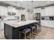 Spacious kitchen features white cabinets, stainless steel appliances, a large island with seating, and hardwood floors at 10823 Preservation Park Dr, Charlotte, NC 28214