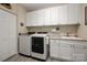 Well-equipped laundry room with modern washer, dryer, sink, and ample cabinet space at 10823 Preservation Park Dr, Charlotte, NC 28214