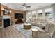 Bright living room with a fireplace, large windows, neutral paint, modern finishes, and plenty of seating at 10823 Preservation Park Dr, Charlotte, NC 28214