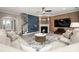 Open-concept living room with a fireplace, hardwood floors, neutral paint, modern decor, and views of the foyer at 10823 Preservation Park Dr, Charlotte, NC 28214