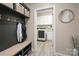 Inviting mudroom with coat hooks, bench seating, and access to the laundry room at 10823 Preservation Park Dr, Charlotte, NC 28214