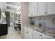 Serving area with granite countertops, white cabinets, and open access to dining at 10823 Preservation Park Dr, Charlotte, NC 28214