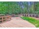 A wooden backyard deck overlooks the yard, and has wooded views and landscaping at 119 Taylor Ct, Mooresville, NC 28117