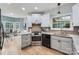 Bright kitchen with white cabinetry, granite countertops, stainless steel appliances, and hardwood floors at 119 Taylor Ct, Mooresville, NC 28117