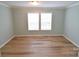 Bright bedroom featuring hardwood floors and natural light from large windows at 121 Silver Fox Ct, Mount Holly, NC 28120