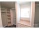 Spacious walk-in closet with custom shelving and storage solutions near a window at 121 Silver Fox Ct, Mount Holly, NC 28120