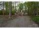 Charming single-story home featuring a front porch, set among beautiful trees, and a spacious gravel driveway at 121 Silver Fox Ct, Mount Holly, NC 28120