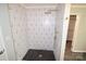 Modern walk-in shower with black and white tiling and gold fixtures at 121 Silver Fox Ct, Mount Holly, NC 28120