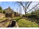 Spacious backyard with a manicured lawn, garden beds, and mature trees offering privacy and shade at 1212 Queens Rd, Charlotte, NC 28207