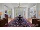 Elegant foyer features hardwood floors, a chandelier, and a round table with rug at 1212 Queens Rd, Charlotte, NC 28207