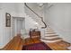 Bright foyer with wooden staircase, hardwood floors, and a decorative chandelier at 1212 Queens Rd, Charlotte, NC 28207