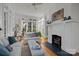 Sunlit living room featuring a white fireplace, large windows and hardwood floors at 1212 Queens Rd, Charlotte, NC 28207