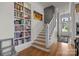 Bright foyer featuring a wooden staircase and built-in bookcase at 1212 Queens Rd, Charlotte, NC 28207