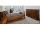 This bedroom features carpet, natural light, a wooden sleigh bed, and a wooden dresser at 124 Benford Dr, Troutman, NC 28166