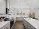 Modern kitchen featuring gray cabinets, stainless steel appliances, hardwood floors and a spacious island at 124 Benford Dr, Troutman, NC 28166